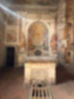 altar inside a church with frescoes on the wall