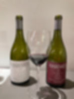 two bottles of wine and a glass with red wine